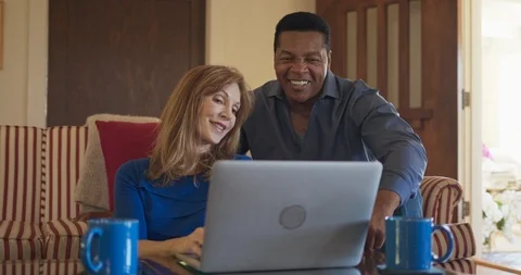 Senior couple using laptop computer together in living room Vídeo Stock 116802484