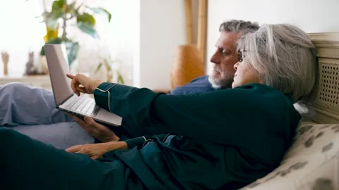 Senior couple using a laptop computer in bed Stock Footage 332604146