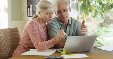 Senior couple using laptop computer to pay bills Foto stock