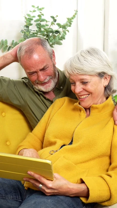 Senior couple using laptop relaxed on the sofa together Stock Footage 291436145