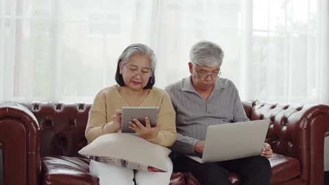 Senior couple using technology device at home Stock Footage 118949498