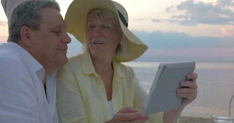 Senior couple using touch pad at the seaside Video stock 61753130