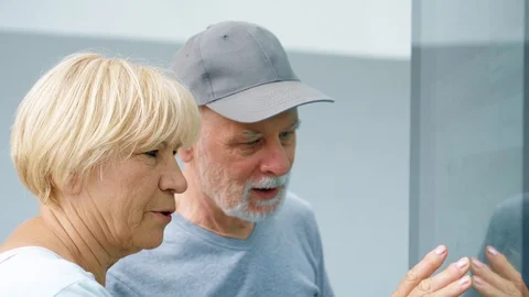 Senior couple using touchscreen. Female making gestures by touching screen Stock Footage 94878251