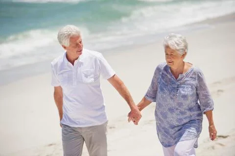 Senior couple walking on the beach Stock Photos