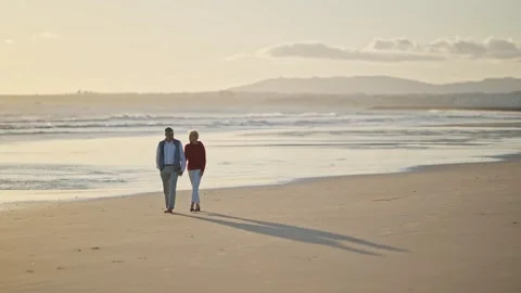 Senior couple walking on beach at sunset Stock Footage 309686517