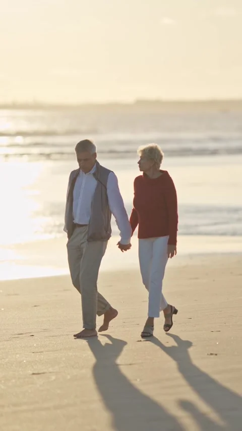 Senior couple walking on beach at sunset Stock Footage 327715168