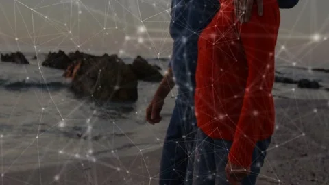 Senior couple walking shore, camera panning revealing embrace, mesh overlay Stock Footage 333004703