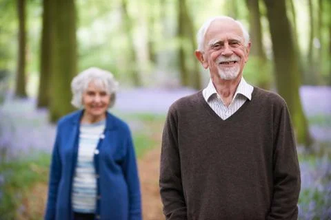 Senior Couple Walking Through Bluebells Woods Stock Photos