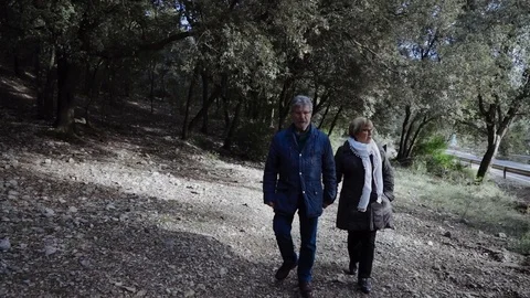 Senior couple walking through the woods Stock Footage 101778574