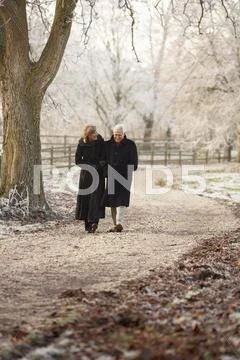 Senior Couple On Winter Walk Through Frosty Landscape Stock Photos