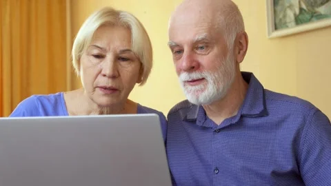 Senior couple work from remote home office on laptop. Wealthy family receiving Stock Footage 130730508