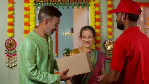 Senior couples receiving parcel or package from delivery person at home door Video stock 252742312