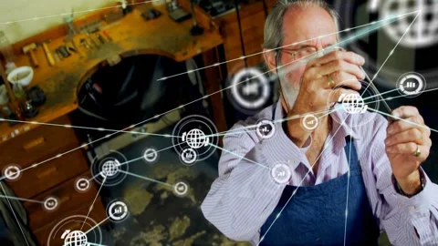 Senior craftsman at bench inspecting wire, network nodes emerging from left Stock Footage 330195362