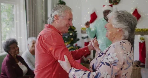 Senior dancing couple holding hands, leading holiday dance near tree while Stock Footage 330917264