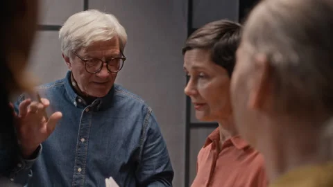 Senior Director Discussing Script with Actors during Rehearsal Stock Footage 311454267