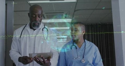 Senior doc tapping tablet, nurse looking in hall sparking 3D globe, waveform for Stock Photos