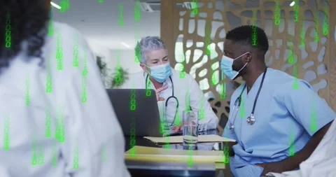Senior doctor pausing typing, speaking to medical team with green code on laptop Stock Footage 326882055