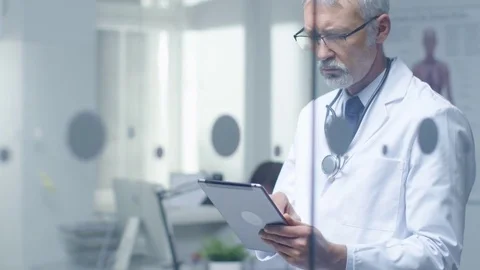 Senior Doctor Thinking About Patient's Diagnosis and Typing on a Tablet Computer Stock Footage