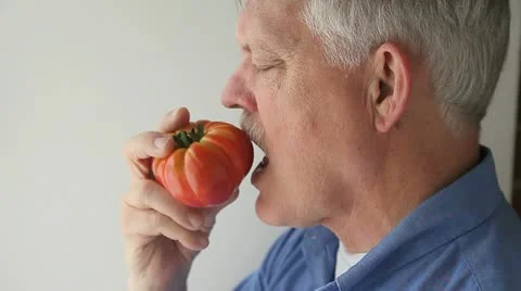 Senior eats tomato Stock Footage 22369061