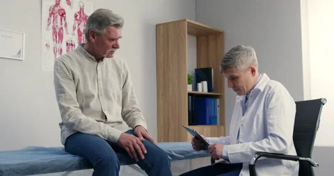 Senior elder man patient talking to male doctor family therapist in hospital Video stock 155642957