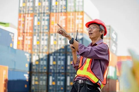 A senior elderly Asian worker engineer wearing safety vest and helmet standin Stock Photos