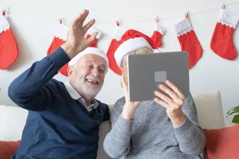 Senior elderly caucasian old man and woman, using conference on tablet with f Stock Photos