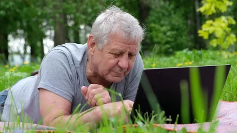 Senior elderly man working on computer laptop outside, in the park Stock Footage 132311362