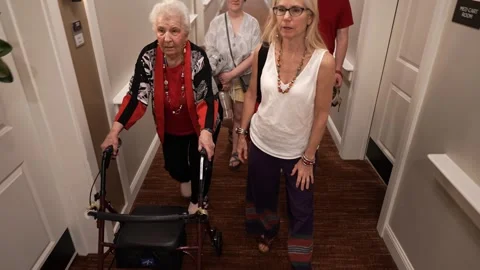 Senior elderly old mother using a walker, daughter, grandson and girlfriend with Stock Footage 282030469