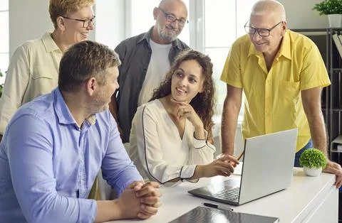 Senior employees learning computer skills with instructor in modern office Фото