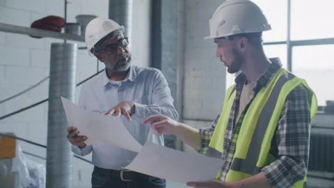 Senior Engineer and Contractor Discussing Floor Plans on Construction Site Stock-Footage 332248651