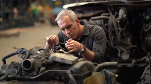 Senior engineer checking old used car engine in machinery parts shop warehous Stock Footage 153569115
