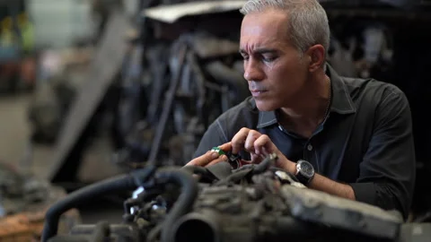 Senior engineer checking old used car engine in machinery parts shop warehous Stock Footage 153569175