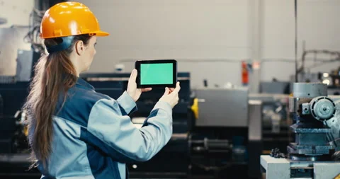 Senior engineer girl in a worker suit and helmet works on a tablet pc Stock Footage 167786853