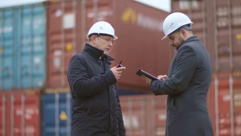 A senior engineer gives instructions to his colleague while loading containers Video stock 306217450
