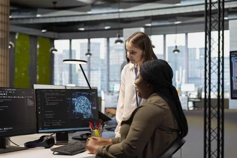 Senior engineer showing junior dev how to adjust deep learning algorithms Stock Photos