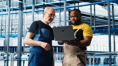 Senior engineer in smart photovoltaics factory guiding new trainee Stock Photos
