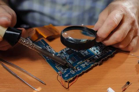 Senior engineer soldering computer board Stock Photos