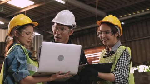 Senior engineer talking to two young female engineers about delayed production Stock Footage 130191421