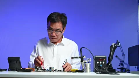 Senior engineer working on computer hardware diagnostics at modern workstat.. Stock Footage 312773642