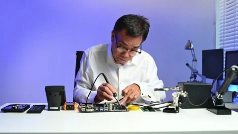 Senior engineer working on computer hardware diagnostics at modern workstat.. Stock Footage 312773708