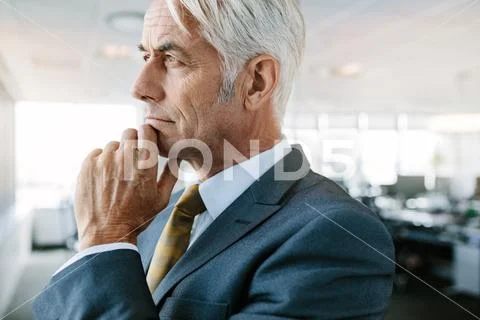 Senior entrepreneur looking pensive in office Stock Photos