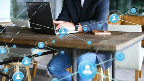 Senior exec typing on laptop while pulsing blue node starting network growth Stock Footage 330563436