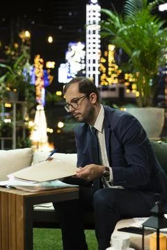 Senior executive reading document in folder at table Фото