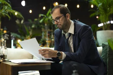 Senior executive reading document in folder at table Фото