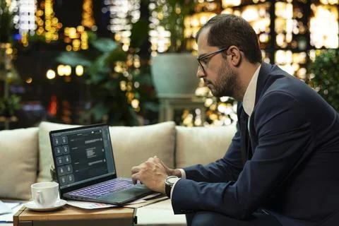 Senior executive uses virtual assistant software on laptop at night Фото