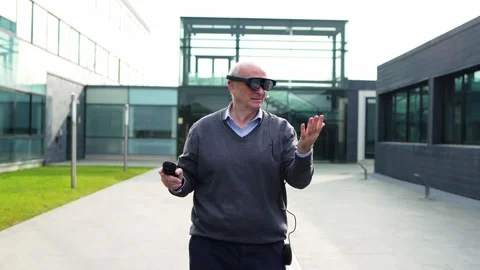 Senior Executive Using Virtual Reality Glasses and Controller in Modern Offic Stock Footage 275860949