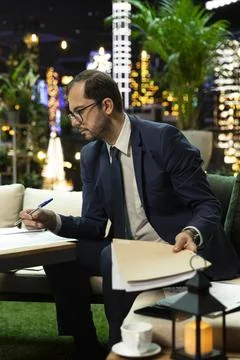 Senior executive writing notes while holding folder after forecasting Фото