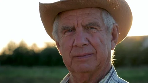 Senior farmer looking at camera in sunset light Vídeo Stock 307241548