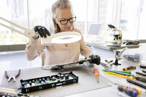 Senior female engineer assembling circuit board Stock Photos