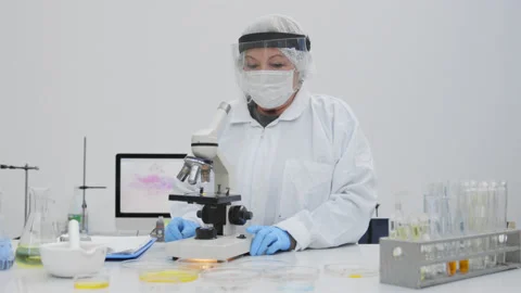 Senior Female microbiologist using a microscope. Stock Footage 147064242